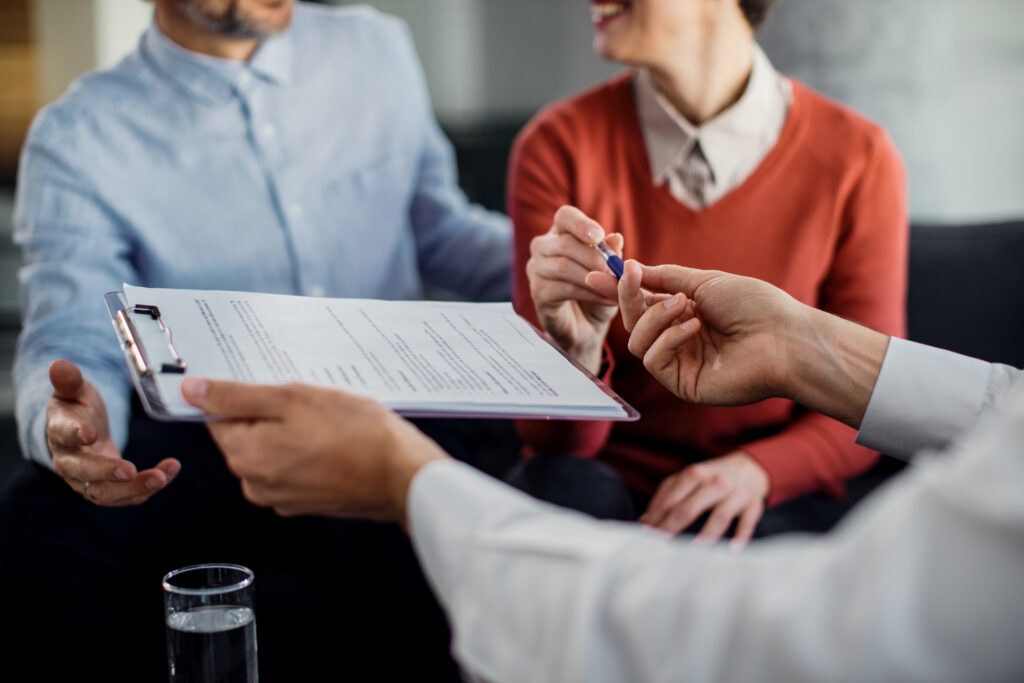Couple signing a long term care insurance application with their financial advisor