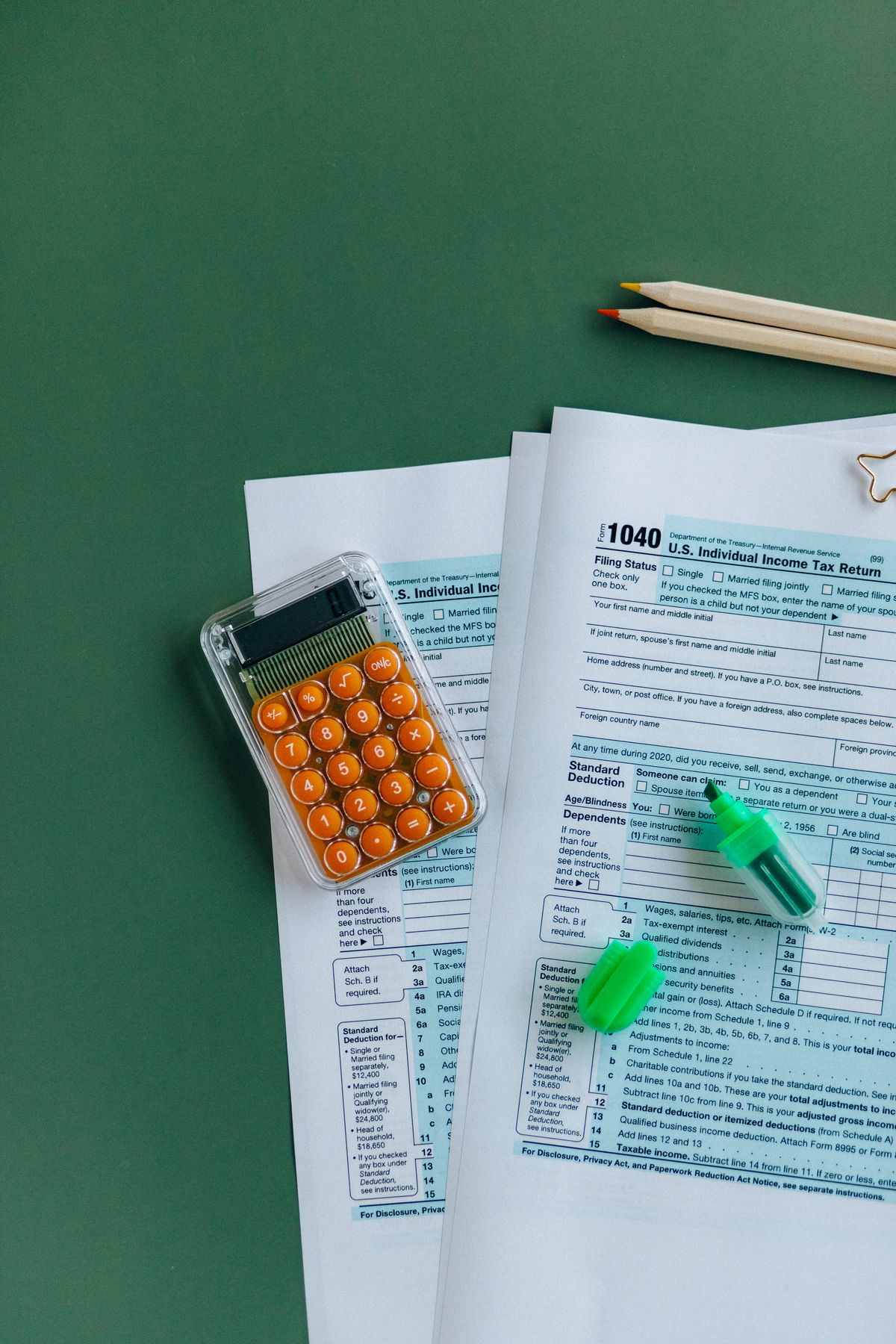 Tax forms and calculator illustrating 409A compliance penalties