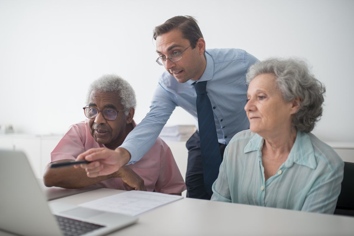 Financial consultant explaining a retirement income strategy to senior clients nearing retirement