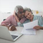 Affluent senior couple reviewing financial documents together while planning their retirement income