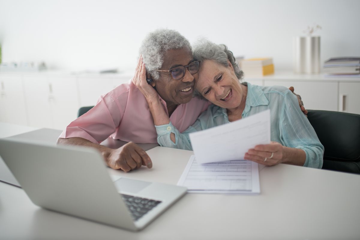 Affluent senior couple reviewing financial documents together while planning their retirement income
