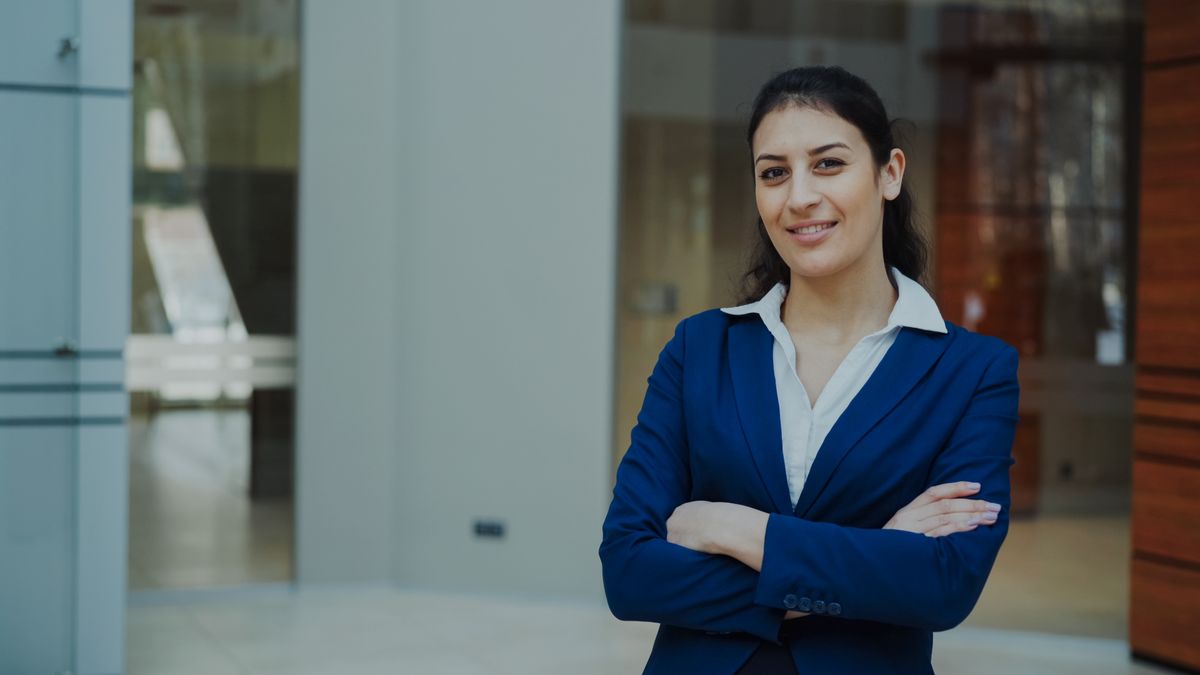 Confident professional woman in a blue suit, representing the key executive talent a business owner needs to retain