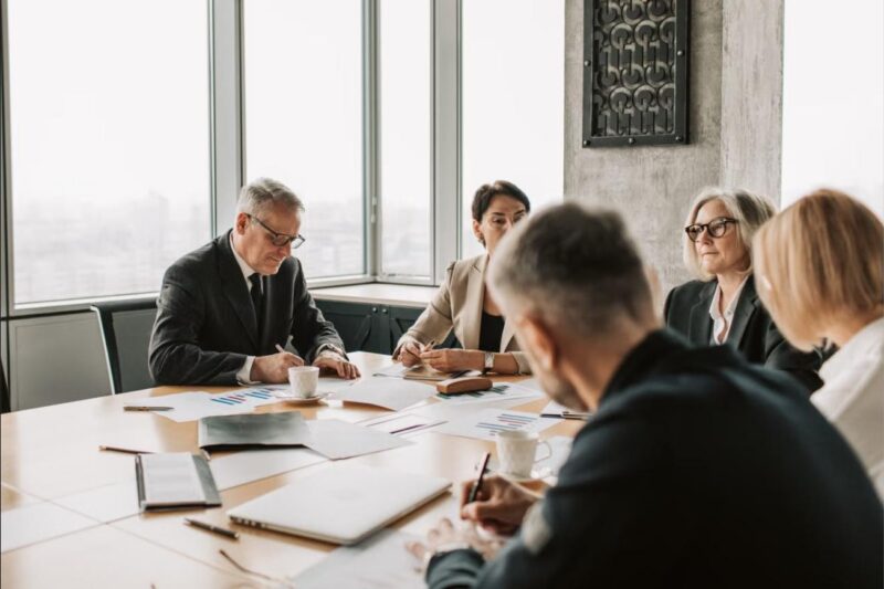 Business owner and executives comparing phantom stock, stock options, and equity options in a boardroom meeting