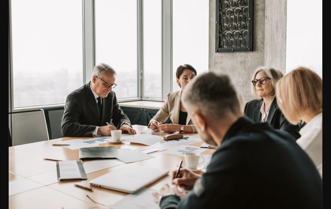 Business owner and executives comparing phantom stock, stock options, and equity options in a boardroom meeting