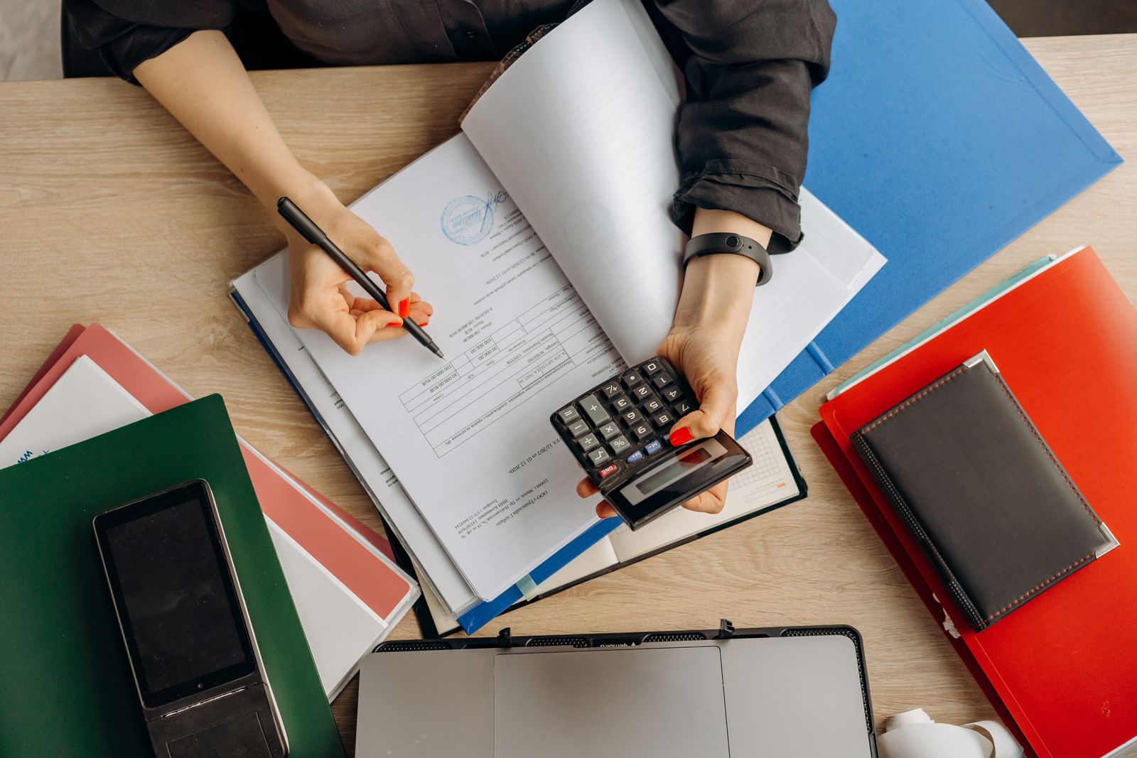 Business owner reviewing cash balance plan contribution figures with a calculator and financial documents
