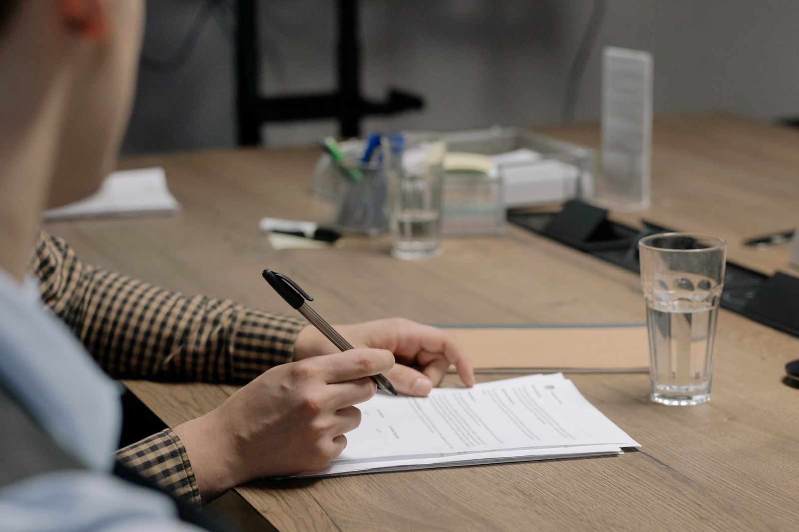 Business owner signing a phantom stock plan agreement at a desk