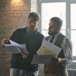 Business owner and advisor reviewing phantom stock plan documents at a mid-sized company