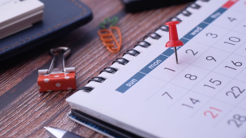 Desk calendar with a red pin marking a year-end planning deadline