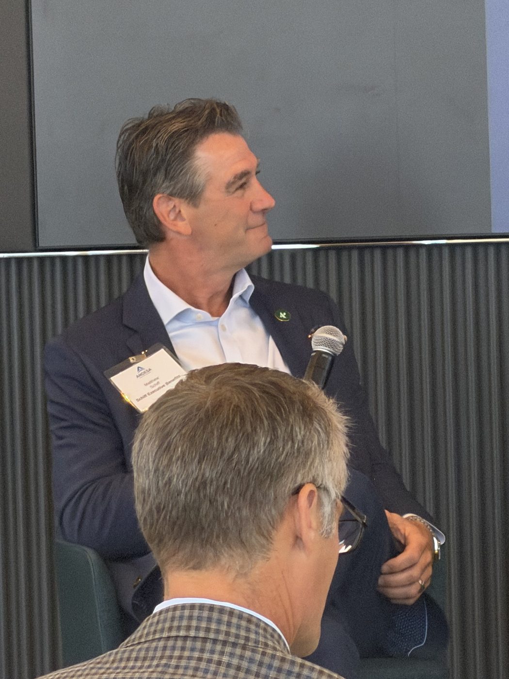 Matt Schiff speaking with a microphone at an industry session