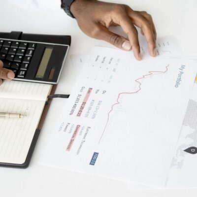 Business owner reviewing financial reports with a calculator during year-end tax planning