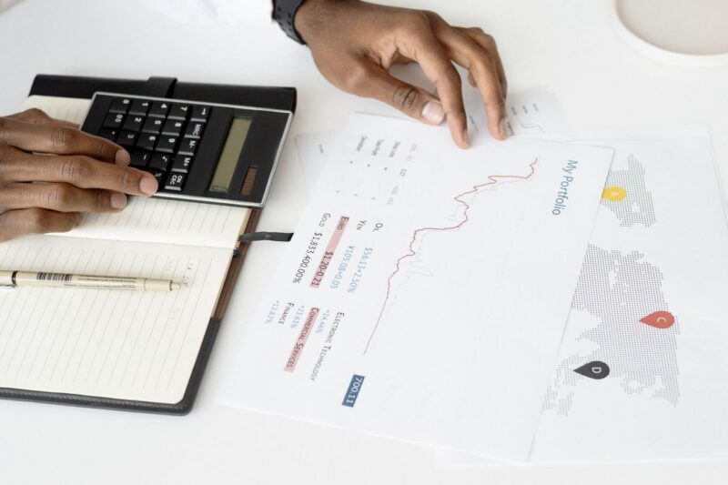 Business owner reviewing financial reports with a calculator during year-end tax planning