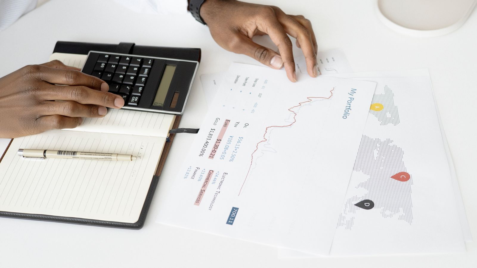 Business owner reviewing financial reports with a calculator during year-end tax planning